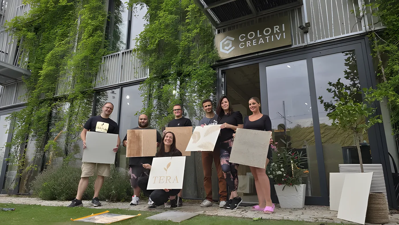 Tým Colori Creativi před showroomem se vzorkovými deskami a značkou Tera